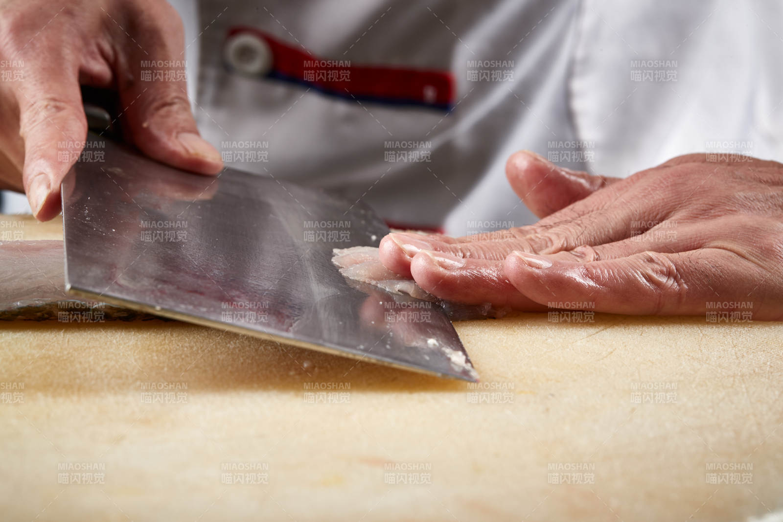 白色砧板上厨师用精湛的刀工展示生鱼片及鲜鱼料理切割分切的刀工
