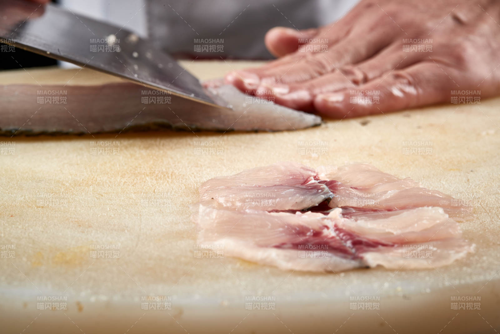 白色砧板上厨师用精湛的刀工展示生鱼片及鲜鱼料理切割分切的刀工