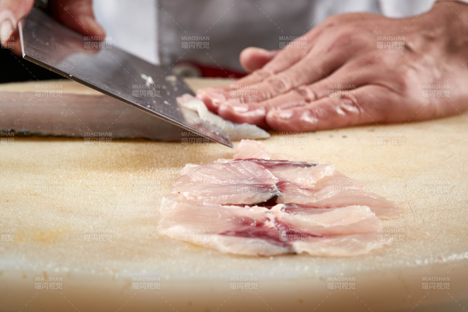 白色砧板上厨师用精湛的刀工展示生鱼片及鲜鱼料理切割分切的刀工