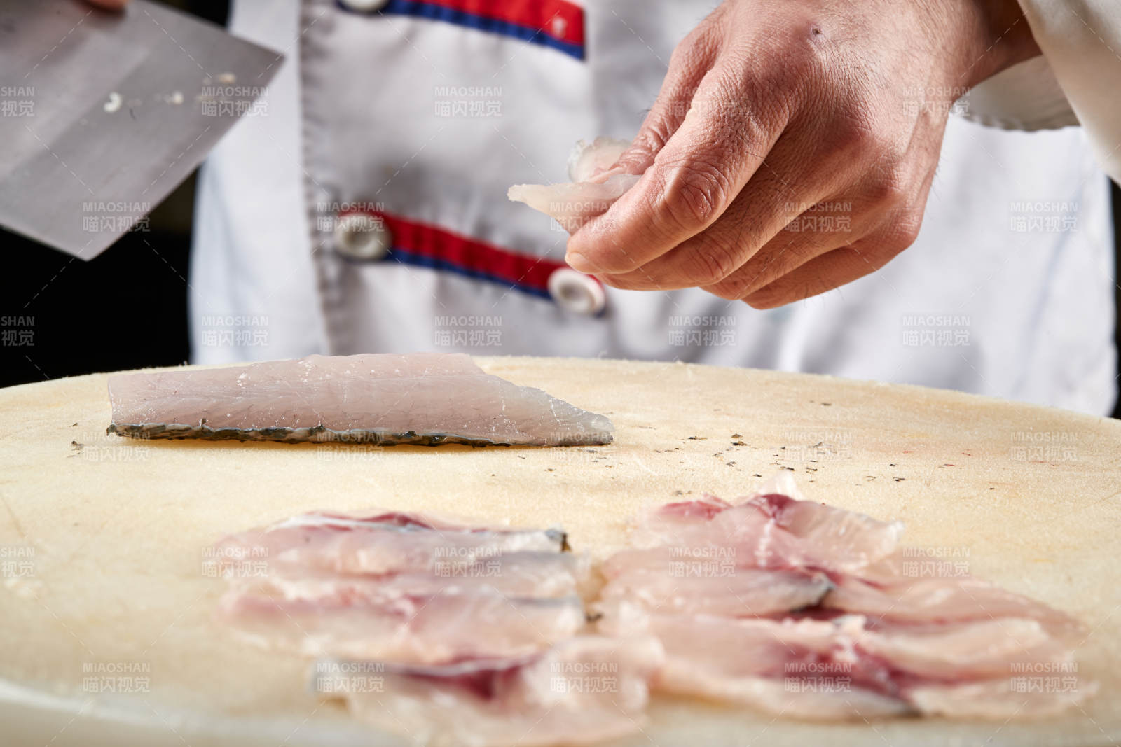 白色砧板上厨师用精湛的刀工展示生鱼片及鲜鱼料理切割分切的刀工