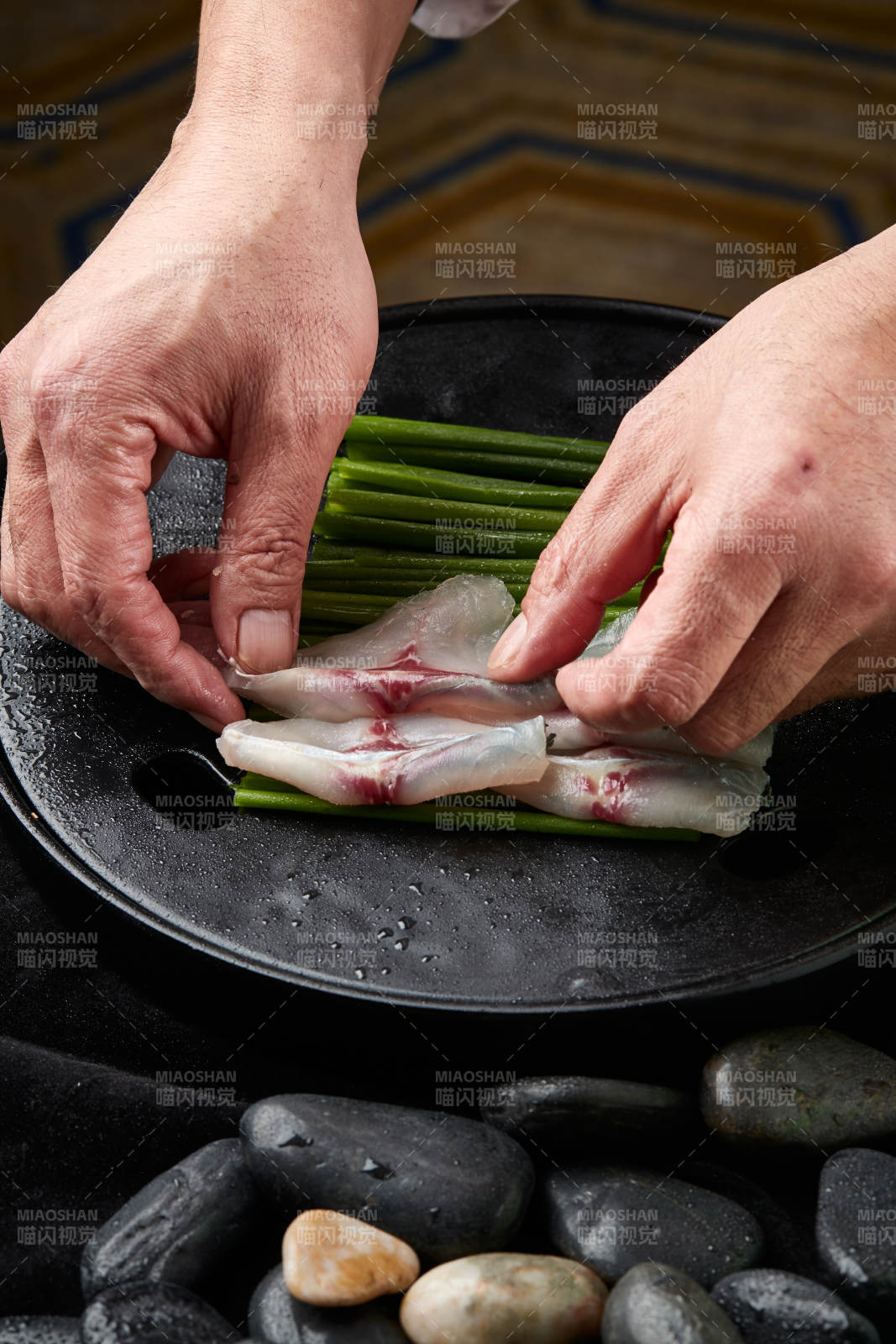 将晶莹白润的鲜鱼片码放在黑色的圆瓷盘上图片
