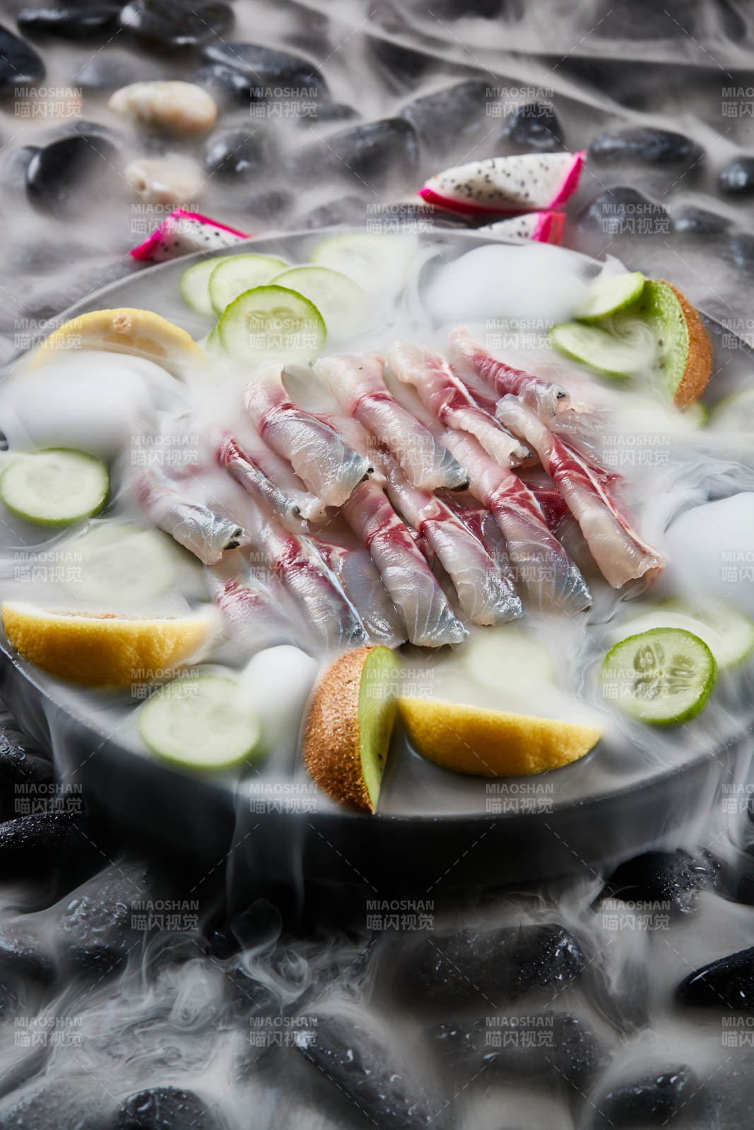 将晶莹白润的鲜鱼片码放在黑色的圆瓷盘上图片