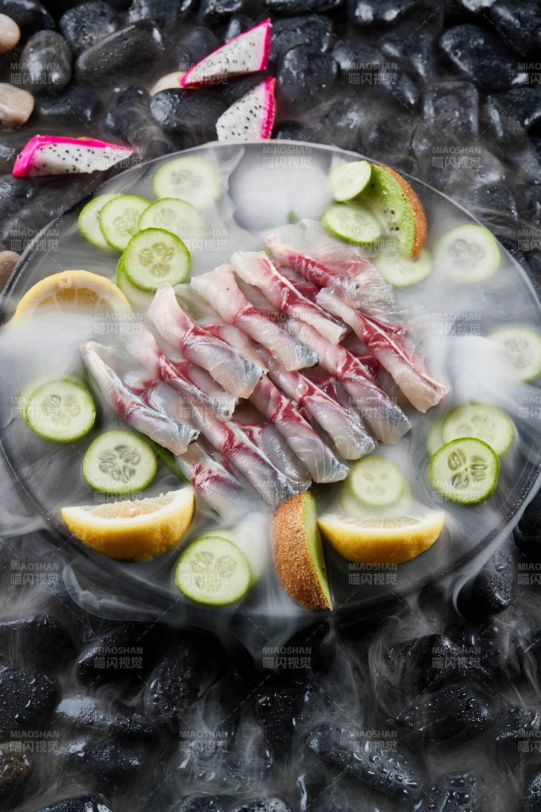 将晶莹白润的鲜鱼片码放在黑色的圆瓷盘上图片