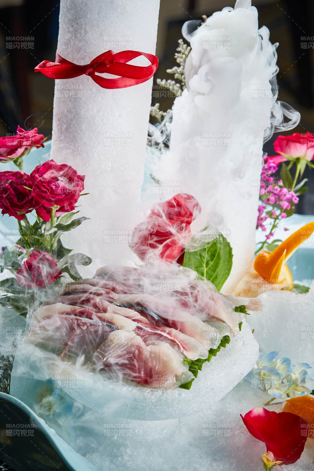 将晶莹白润的鲜鱼片码放在黑色的圆瓷盘上