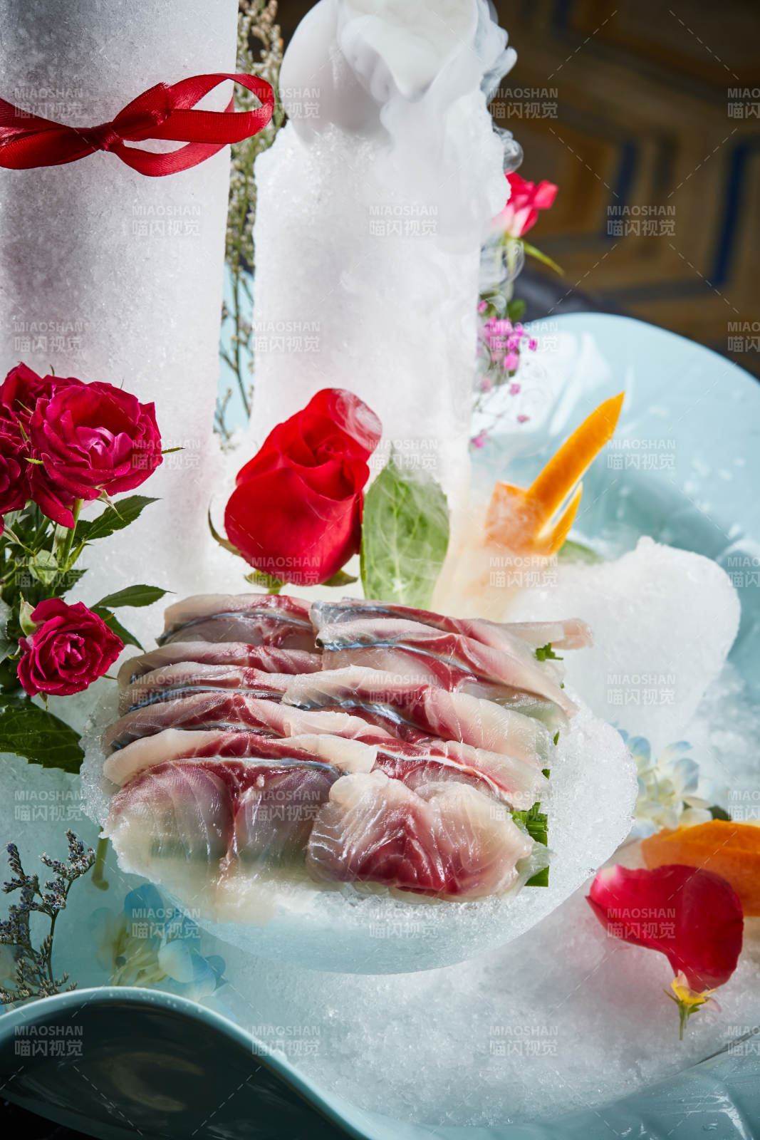 将晶莹白润的鲜鱼片码放在黑色的圆瓷盘上