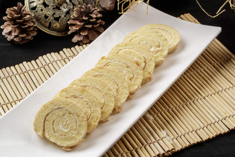 长瓷盘装的夹心奶油蛋糕卷