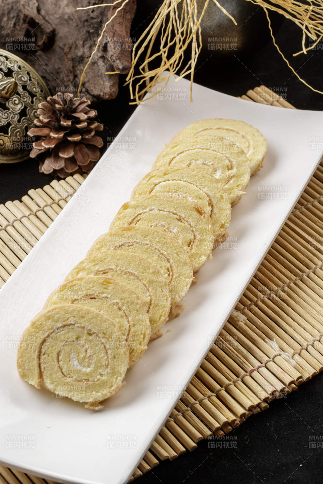 长瓷盘装的夹心奶油蛋糕卷