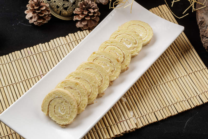 长瓷盘装的夹心奶油蛋糕卷