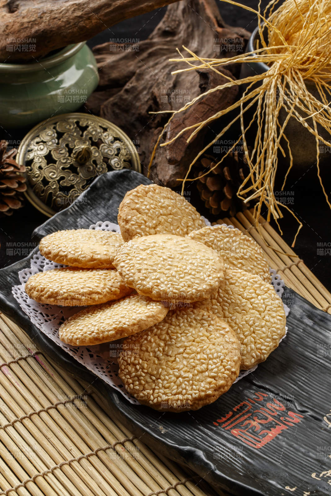 寿司帘上的黑磁盘装的芝麻烤饼