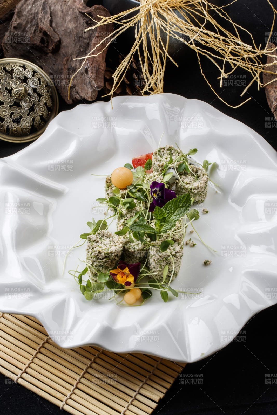 壽司簾上的花邊瓷盤裝的香椿苗麻豆腐