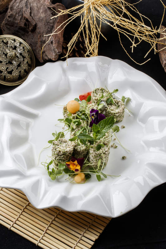 壽司簾上的花邊瓷盤裝的香椿苗麻豆腐