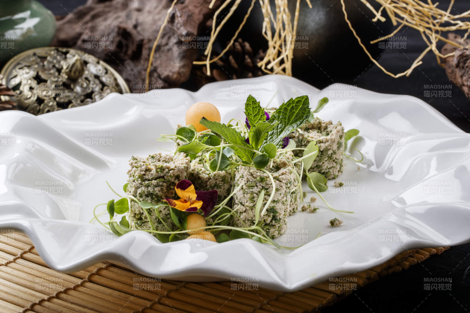 壽司簾上的花邊瓷盤裝的香椿苗麻豆腐