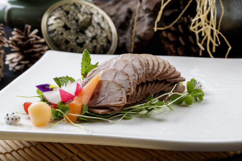 壽司簾上的方瓷盤裝的五香牛腱