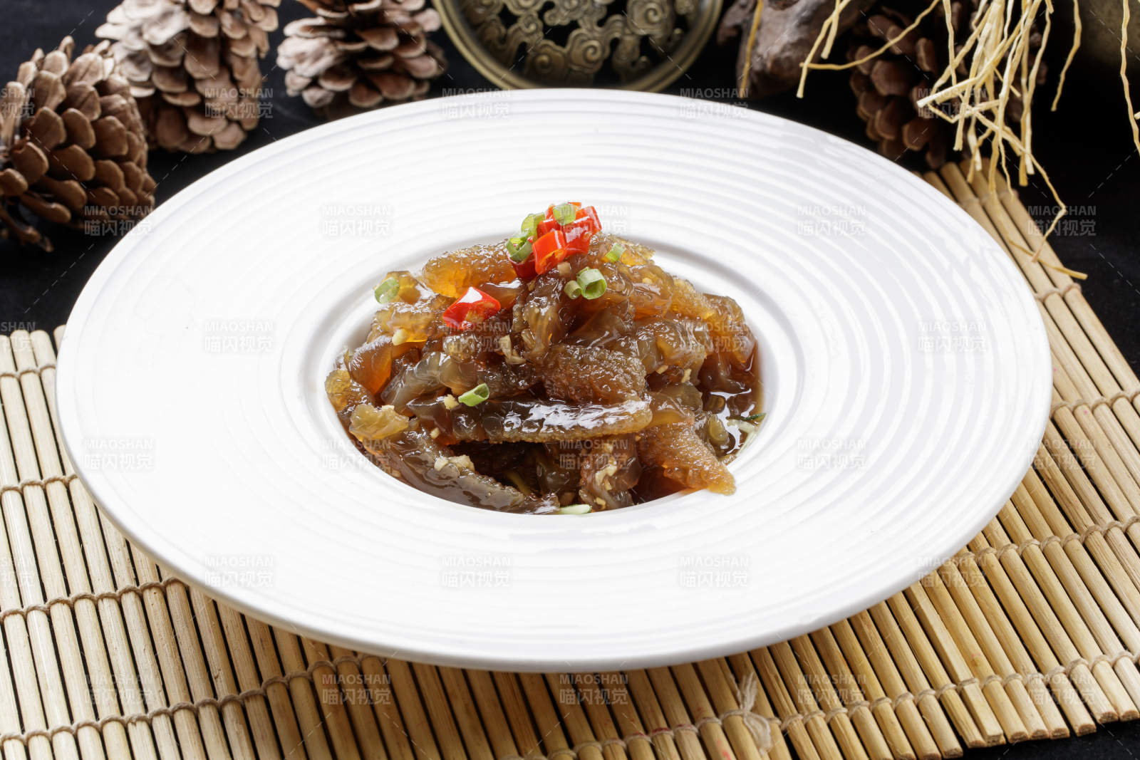 寿司帘上的圆瓷盘装的老醋蛰头