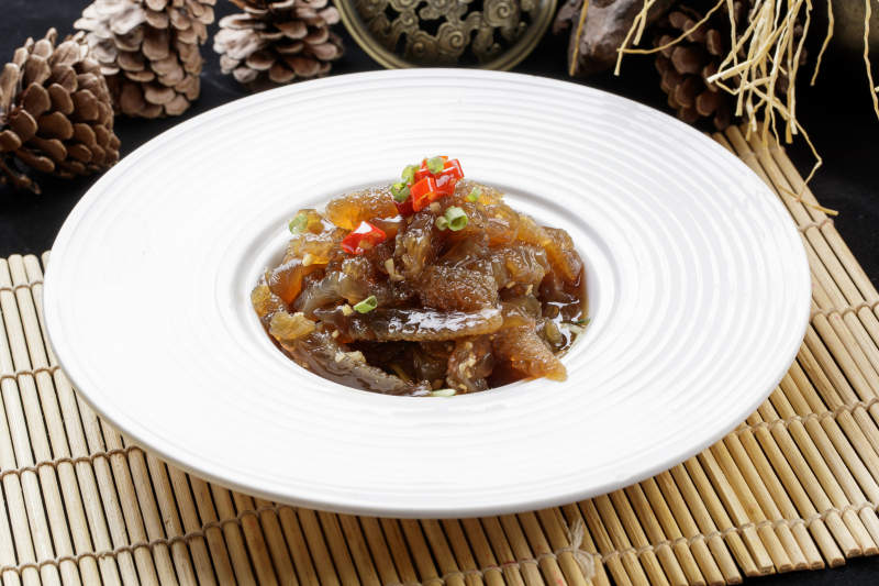 寿司帘上的圆瓷盘装的老醋蛰头