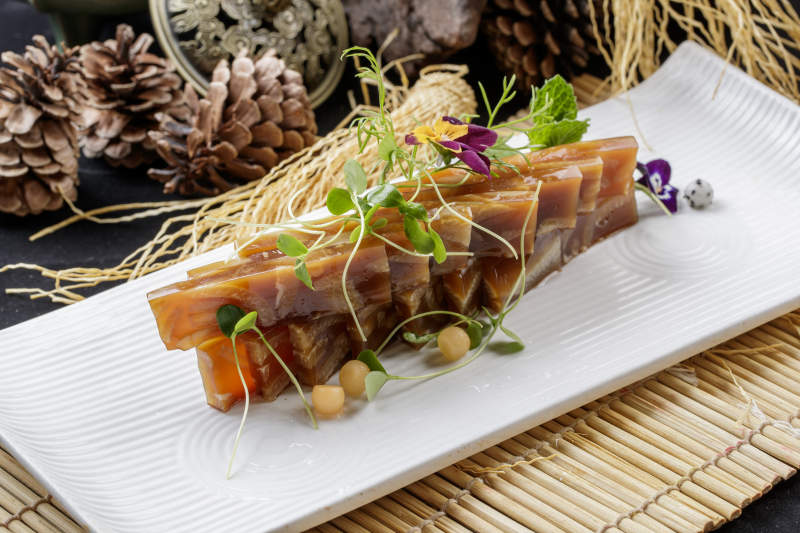 寿司帘上的长瓷盘装的美味猪皮冻