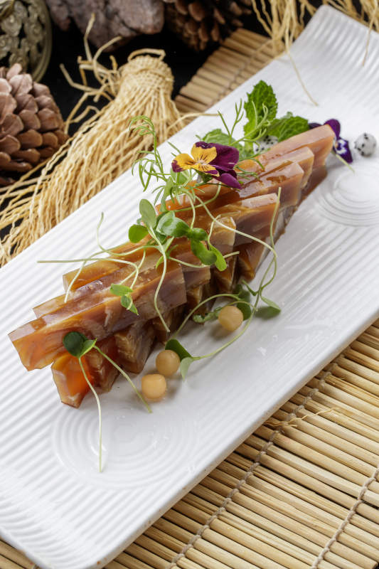 寿司帘上的长瓷盘装的美味猪皮冻