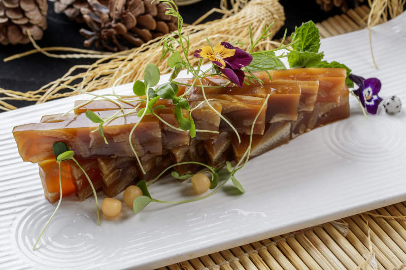 寿司帘上的长瓷盘装的美味猪皮冻