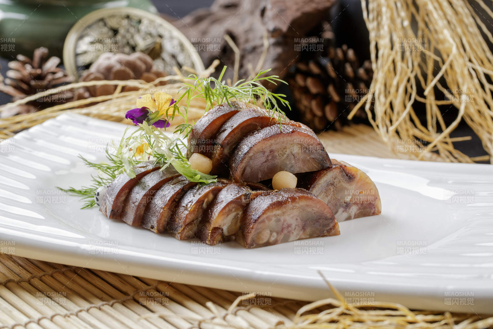 寿司帘上的长瓷盘装的熏肘花