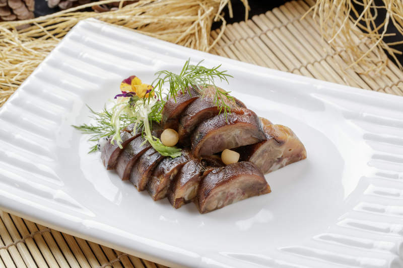 寿司帘上的长瓷盘装的熏肘花