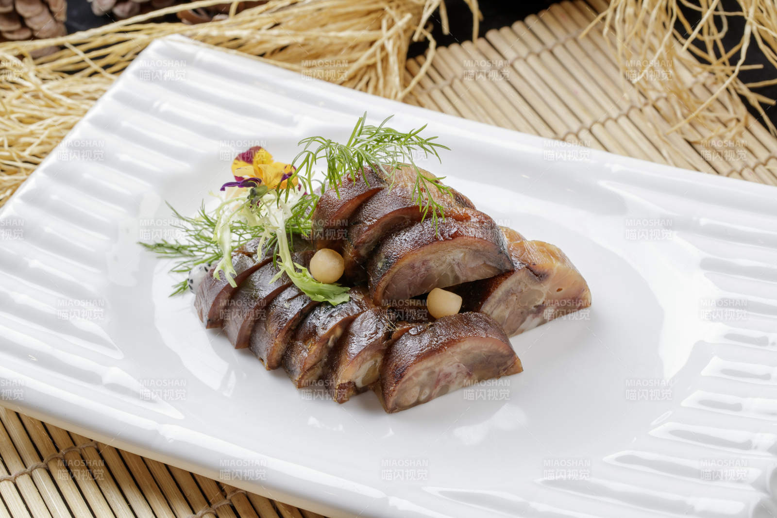 寿司帘上的长瓷盘装的熏肘花