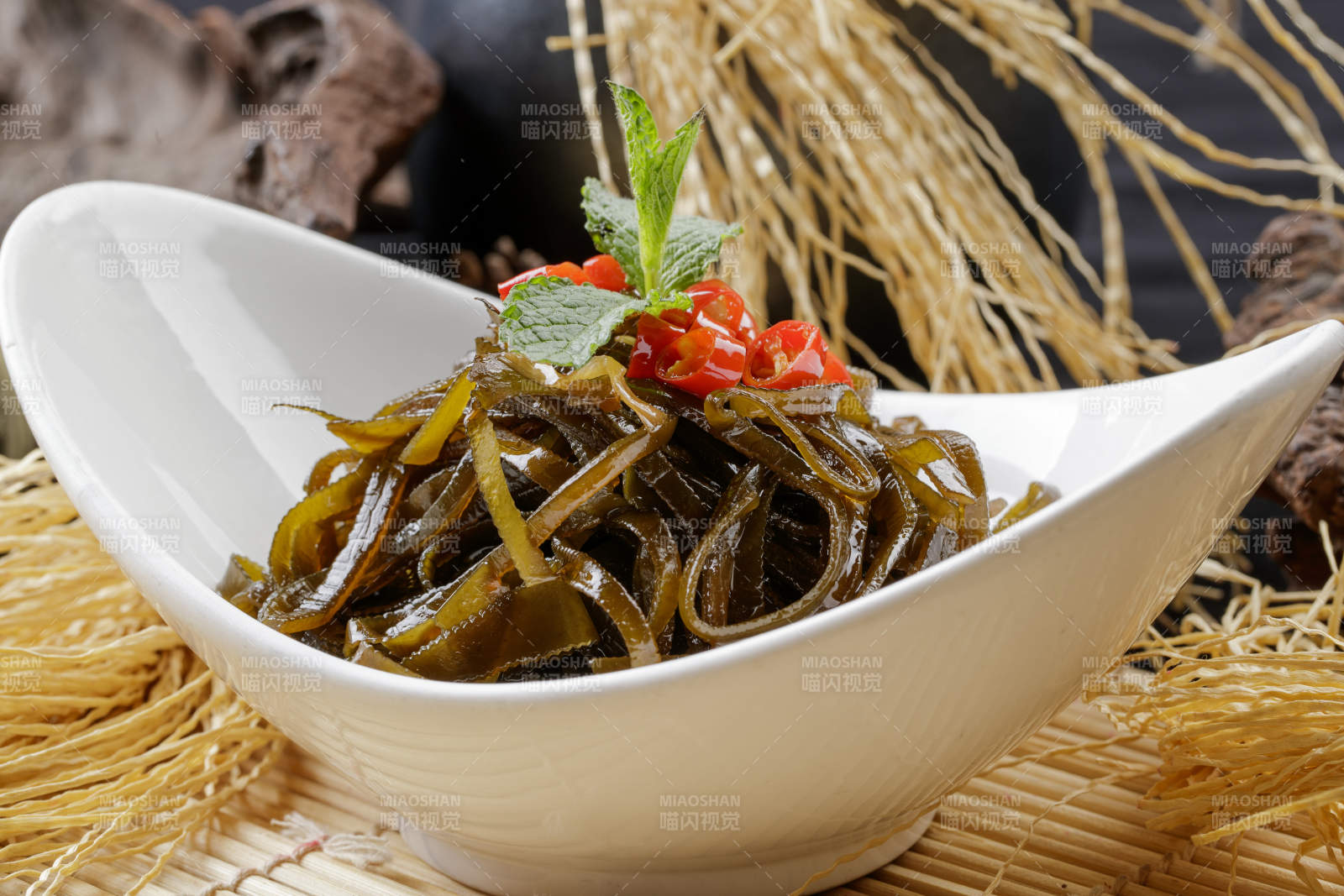 壽司簾上的元寶瓷盤(pán)裝的涼拌海帶絲