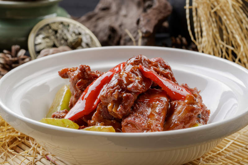 寿司帘上的白色砂锅装的酱小排