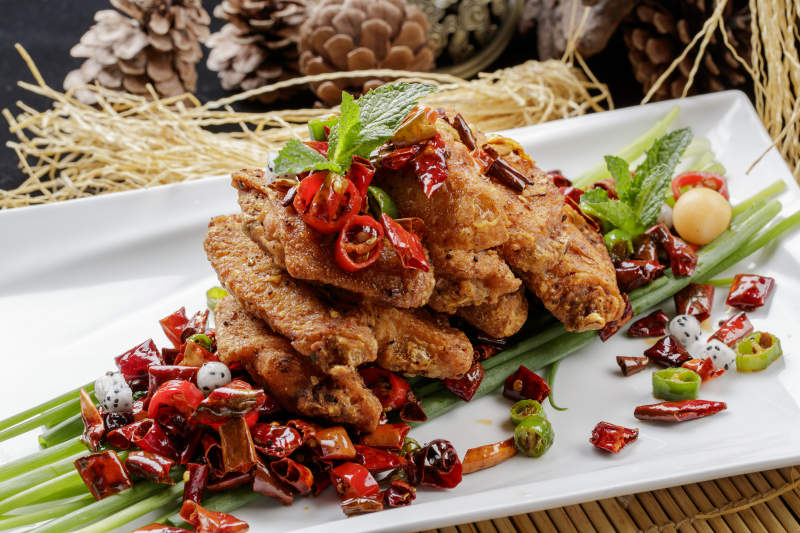 白色瓷盘装的香辣干炸鸡翅中