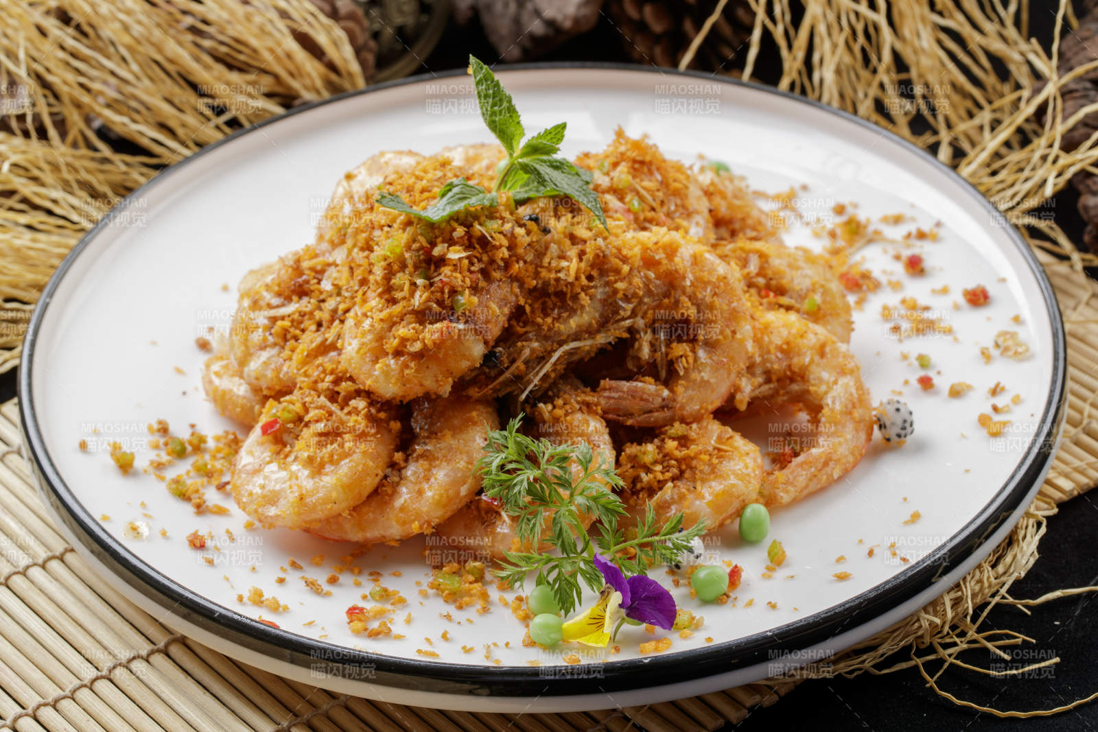 壽司簾上的圓瓷盤裝的酥炸大明蝦