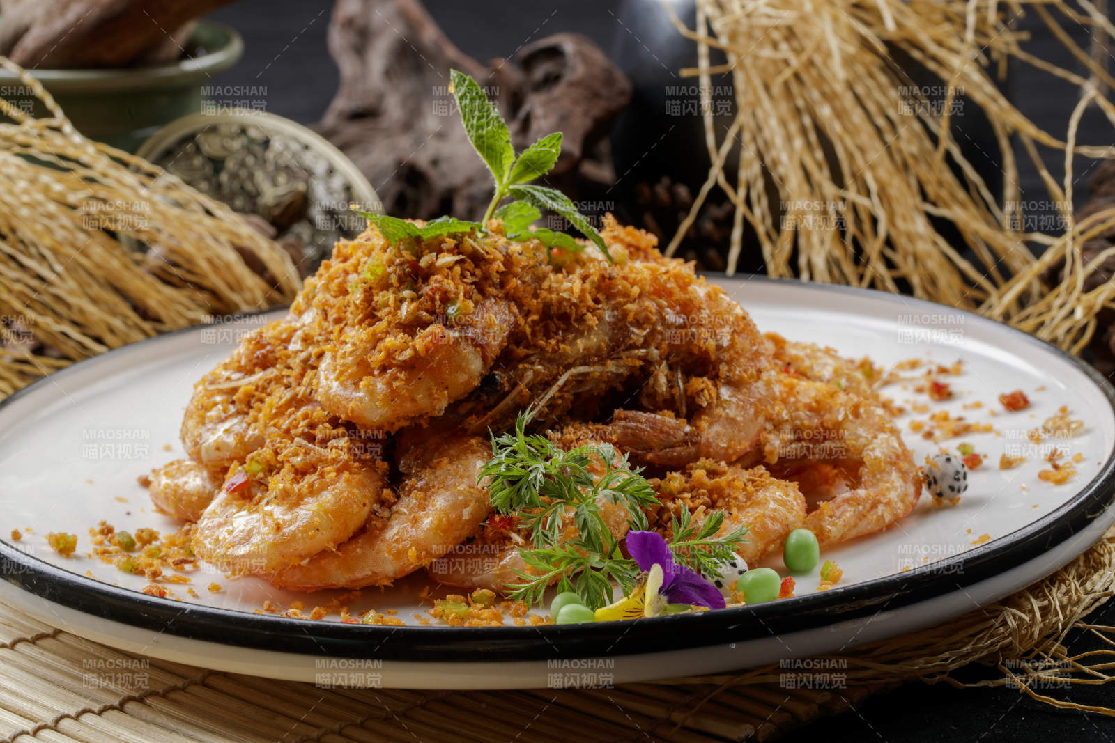 壽司簾上的圓瓷盤裝的酥炸大明蝦