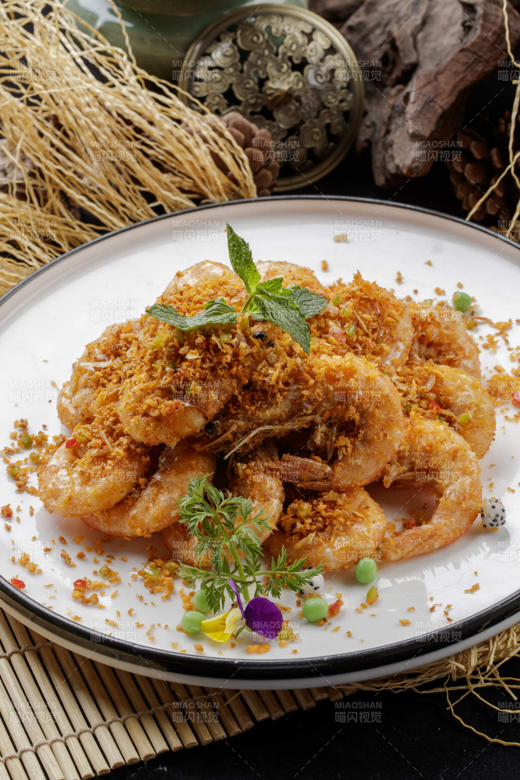 壽司簾上的圓瓷盤裝的酥炸大明蝦