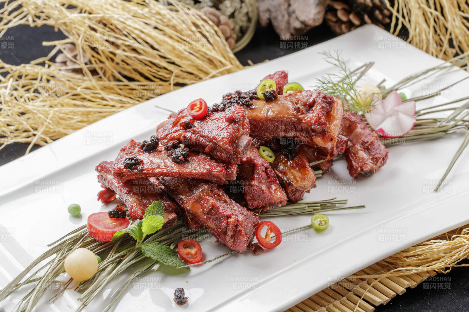 寿司帘上的长瓷盘装的豆豉酱小排-摄影图