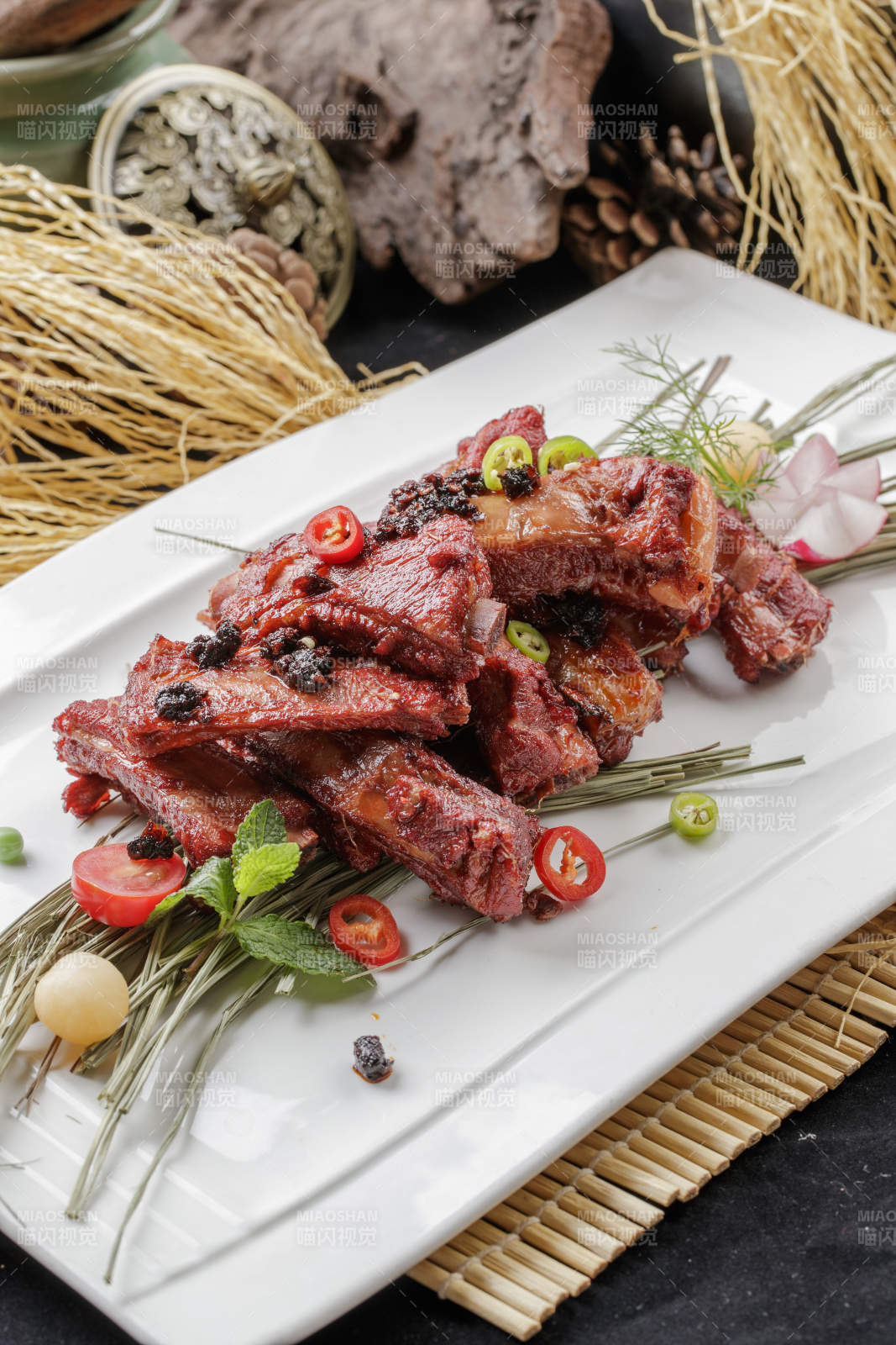 寿司帘上的长瓷盘装的豆豉酱小排-摄影图