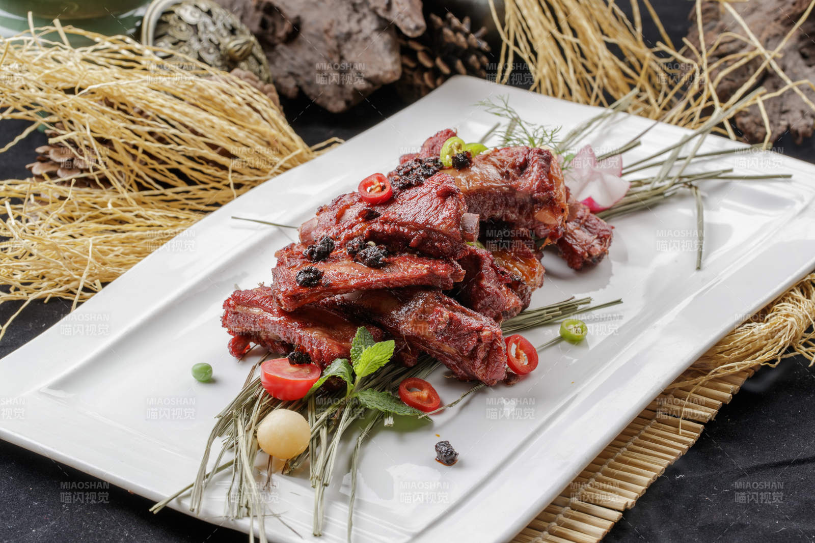 寿司帘上的长瓷盘装的豆豉酱小排-摄影图