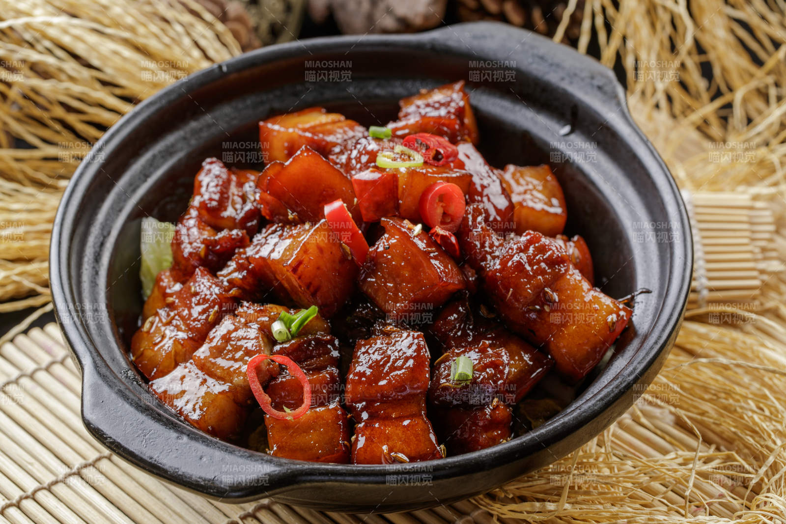 寿司帘上的黑色砂锅装的毛氏红烧肉