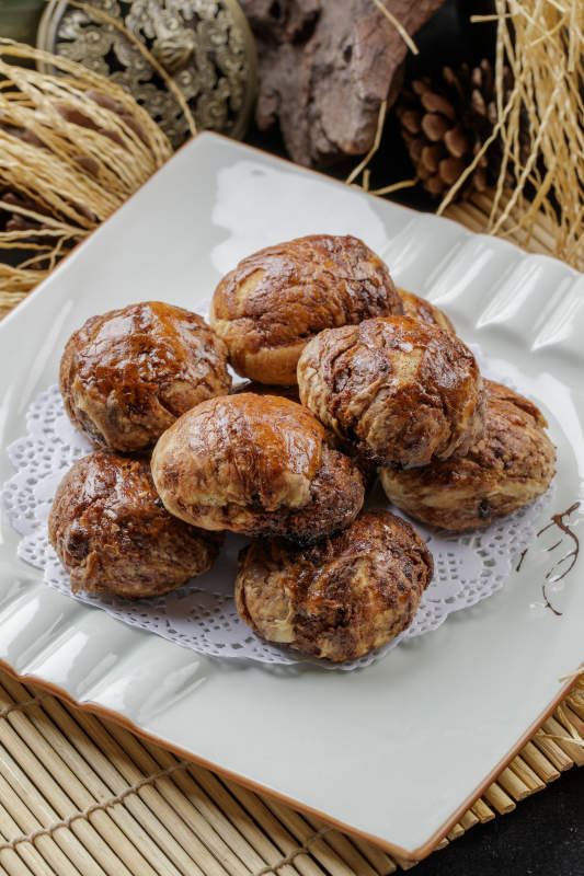 寿司帘上的方瓷盘装的红糖麻酱饼