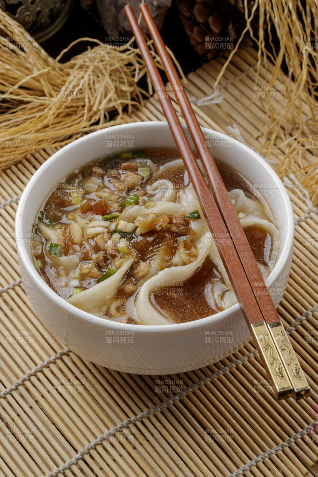 壽司簾上的白瓷碗裝的茄丁打鹵面