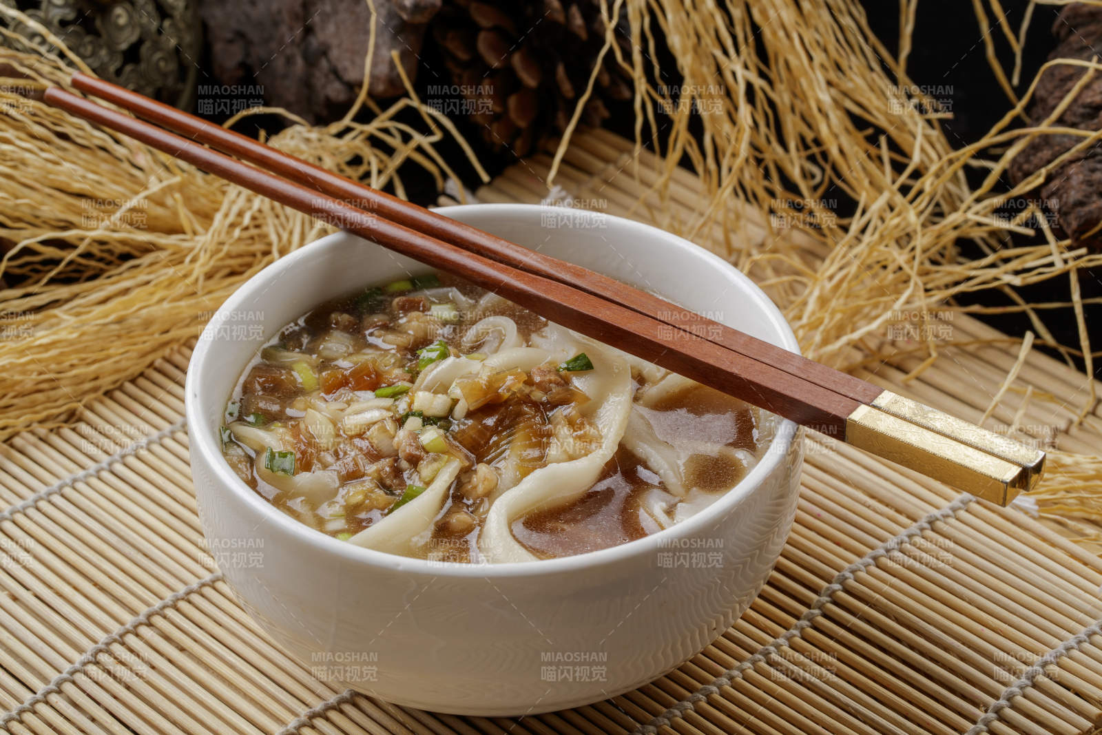 壽司簾上的白瓷碗裝的茄丁打鹵面