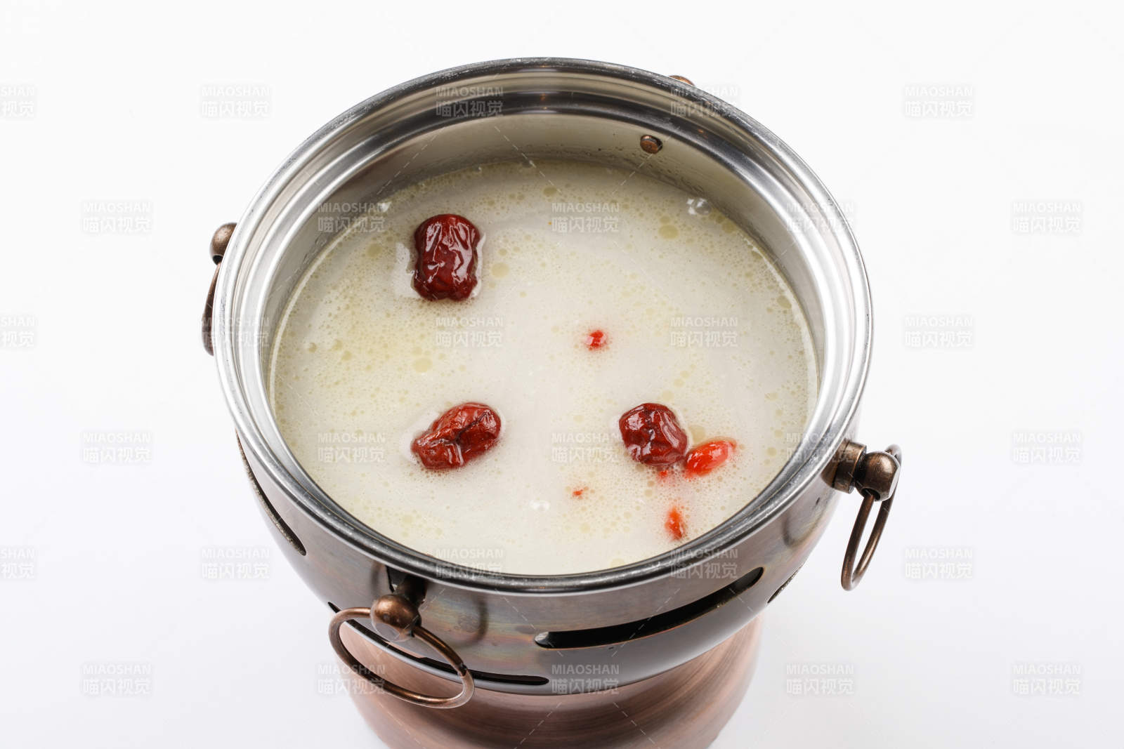 白色背景上的小火鍋裝的大骨奶湯鍋底
