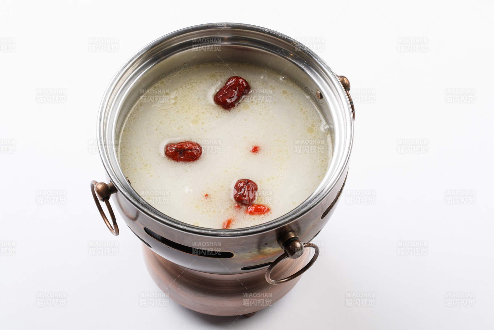 白色背景上的小火鍋裝的大骨奶湯鍋底