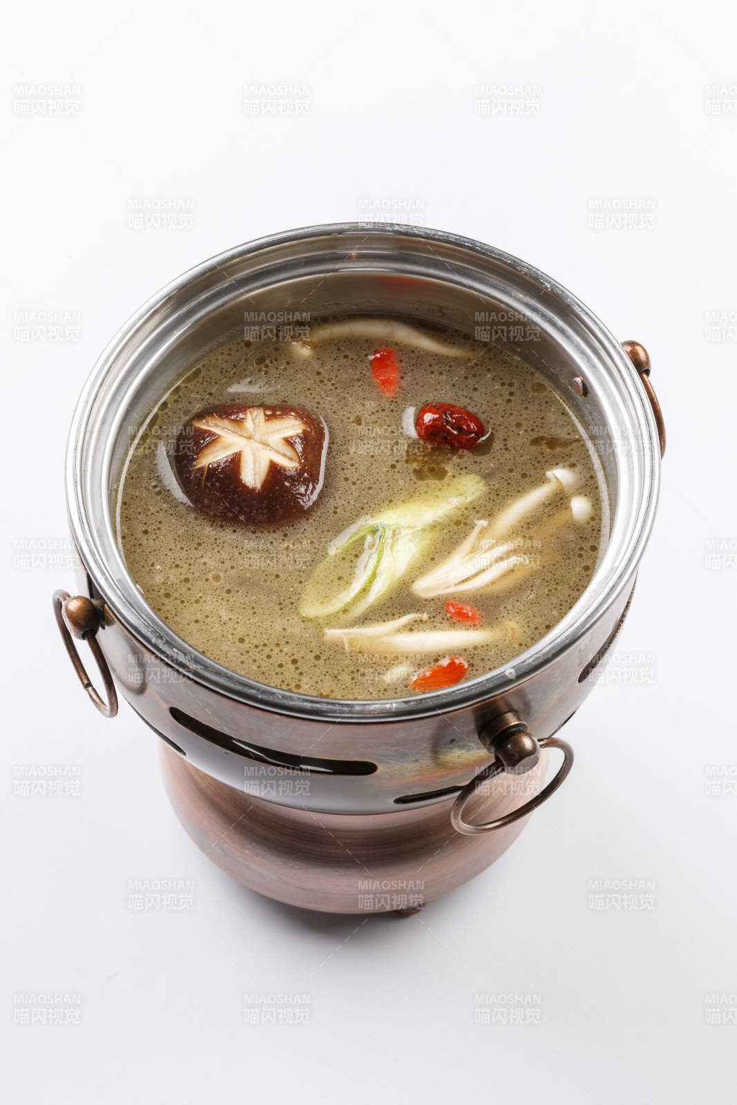 白色背景上的小火鍋裝的菌湯鍋底