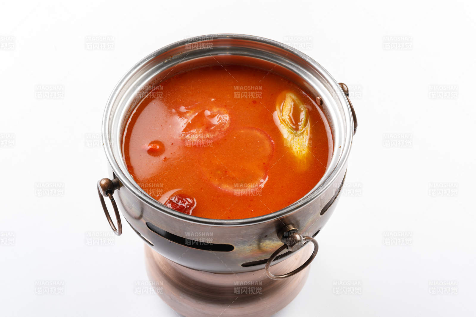 白色背景上的小火鍋裝的番茄鍋底