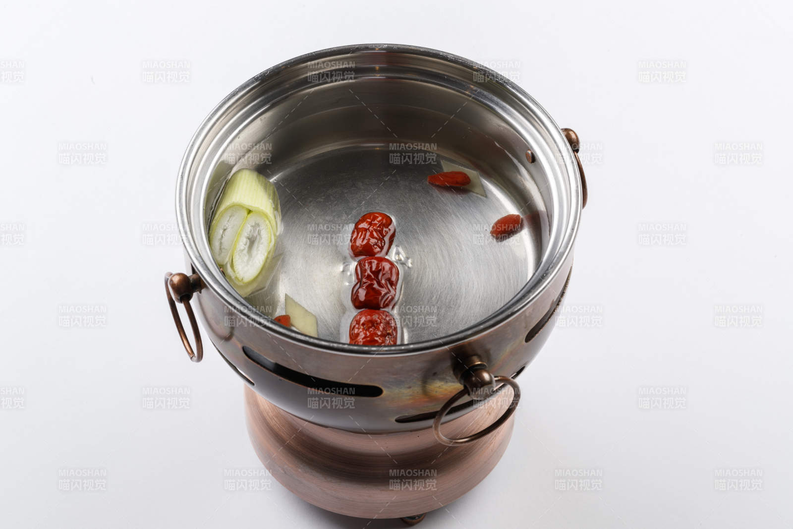 白色背景上的小火鍋裝的清湯鍋底
