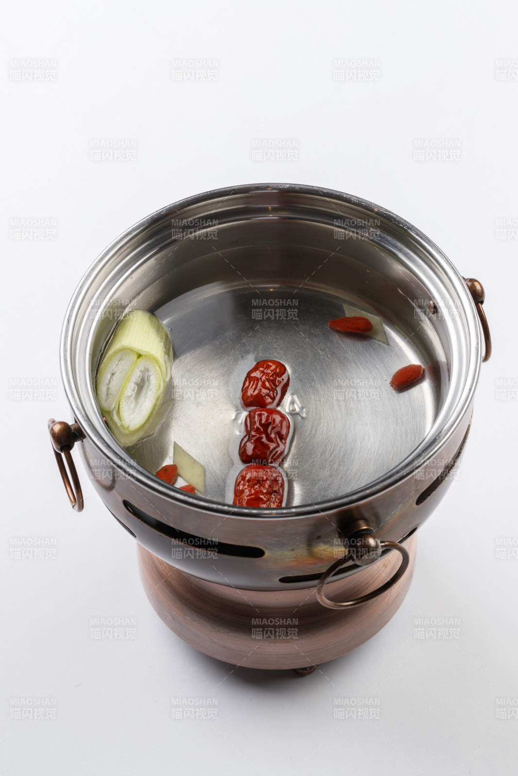 白色背景上的小火鍋裝的清湯鍋底
