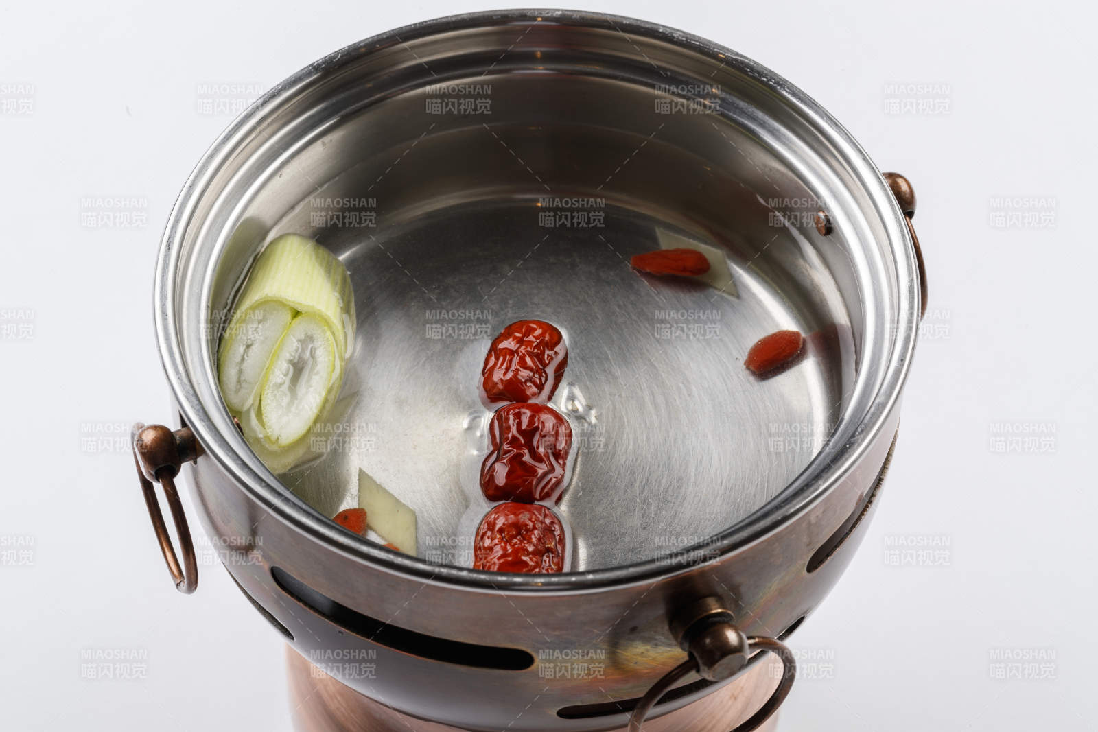 白色背景上的小火鍋裝的清湯鍋底