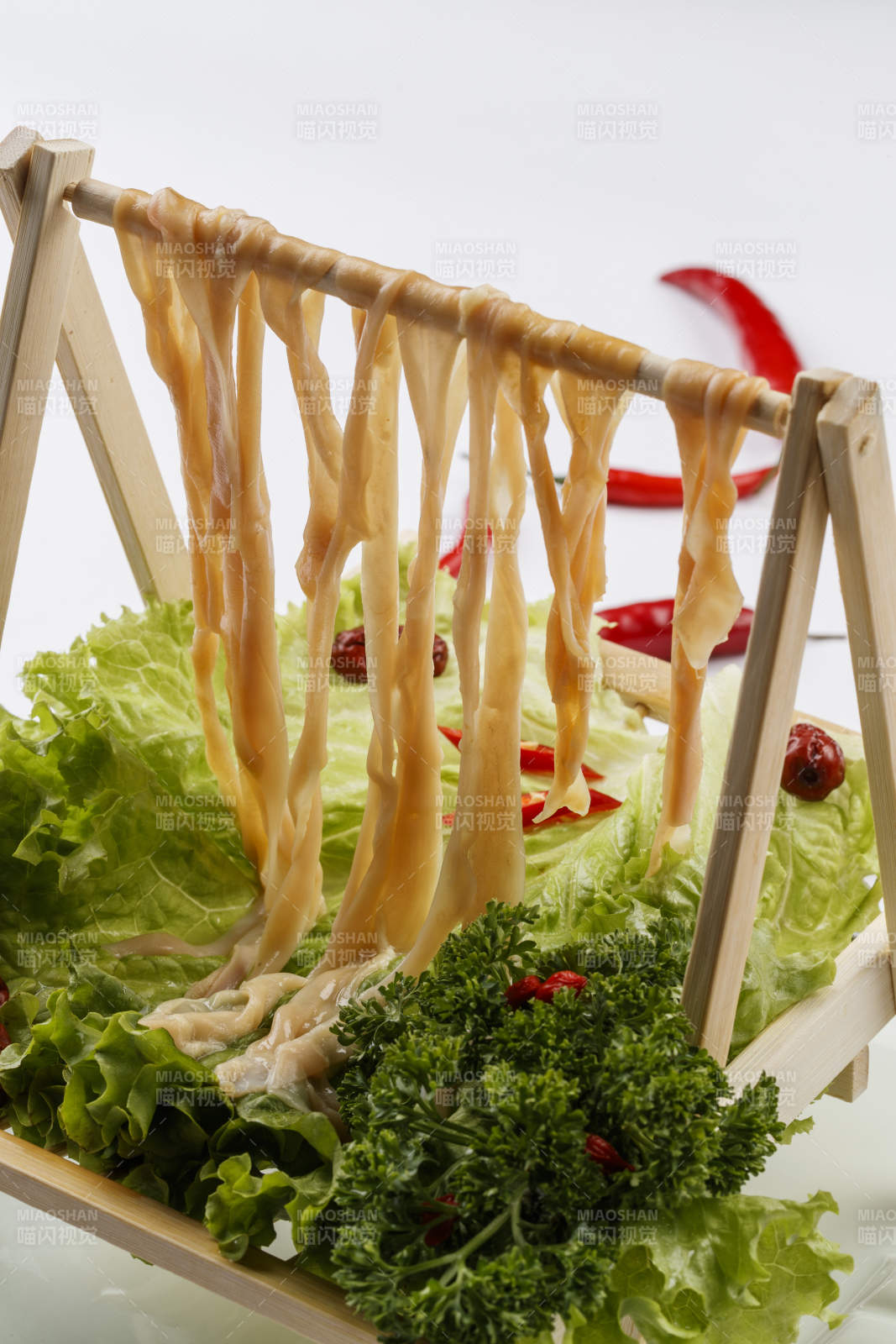 白色背景上的木架挂着的火锅食材新鲜鸭肠