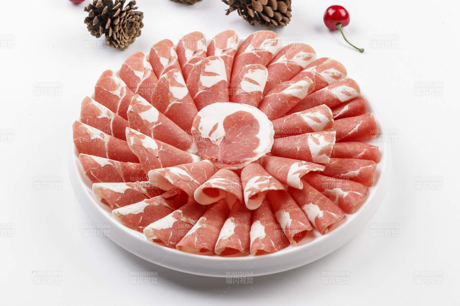 白色背景上的圓瓷盤裝的涮鍋食材肥牛片