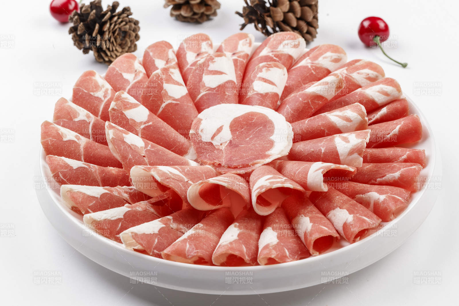 白色背景上的圓瓷盤裝的涮鍋食材肥牛片