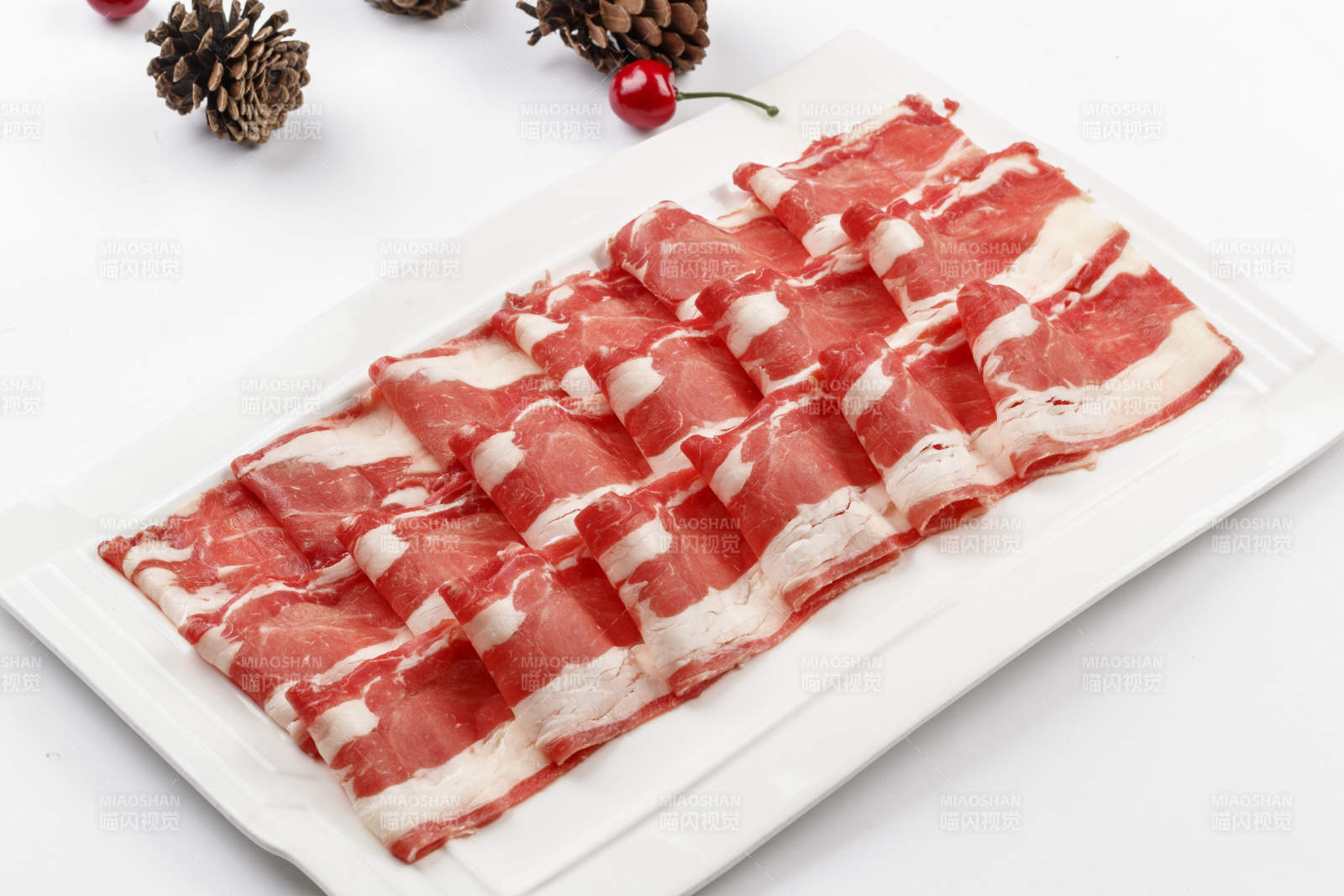 白色背景上的長瓷盤裝的涮肉食材羊肉片