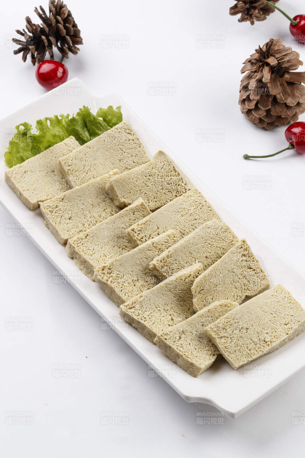 白色背景上的長瓷盤裝的火鍋食材凍豆腐